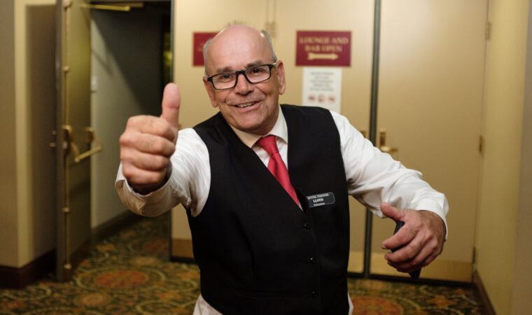 Man smiling in his Capitol Theatre volunteer uniform. He is giving the camera a thumbs up.