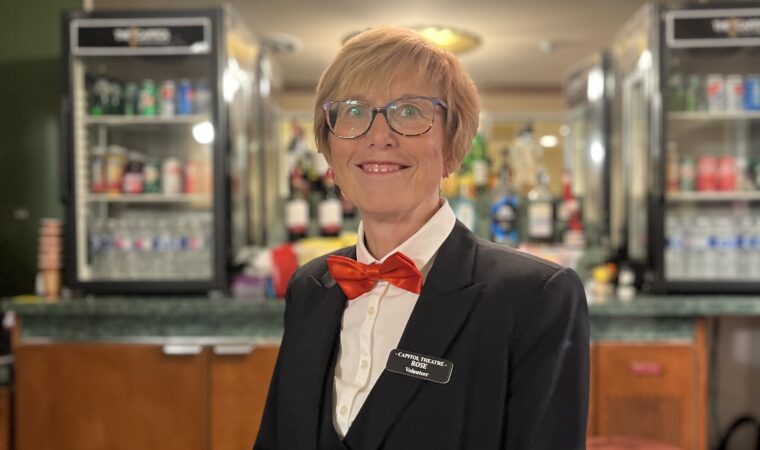 Smiling woman dressed in a suit and bowtie.